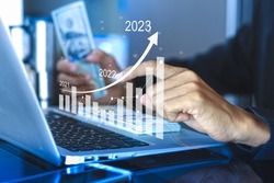 Businessman using a computer show plan business growth and financial, increase of positive indicators to increase business growth and an increase for growing up business from year 2021-2023 
