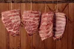 Pile of pork ribs hang at local butcher's shop