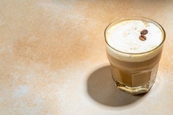 Cold dairy coffee drink with milk, whipped cream. Foamy frappe, latte, cappuccino, on a cream background, space for text. Summer cold coffee cocktail