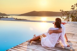 Couple in hug watching sunrise together in Greece