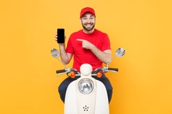 Delivery man in red cap t-shirt uniform driving moped motorbike scooter hold mobile phone isolated on yellow background studio Guy employee working courier Service quarantine pandemic covid19 concept