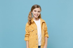 Smiling little blonde kid girl 12-13 years old with two ponytails in yellow jacket, white basic t-shirt looking camera isolated on pastel blue background children studio portrait. Childhood lifestyle.