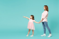 Full length woman in pink clothes have fun with child baby girl 5-6 years old. Mommy little kid daughter walk go step isolated on pastel blue azure background studio. Mother's Day love family concept