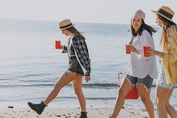 Side view happy female friends young women 20s in straw hat summer clothes hang out together carry food in picnic refrigerator glasses outdoor on sea beach background People vacation journey concept