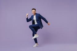Full size body length young successful employee business man lawyer 20s wear formal blue suit white t-shirt work in office do winner gesture celebrate isolated pastel purple background studio portrait