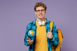 Young boy teen student in casual clothes backpack headphones glasses hold Earth world globe show thumb up isolated on plain violet background studio Education in high school university college concept