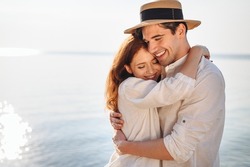 Side view happy young couple two family man woman wear casual clothes girlfriend hugging boyfriend rest date at sunrise over sea sand beach ocean outdoor exotic seaside in summer day sunset evening