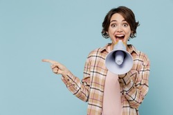 Young cool happy woman 20s in brown shirt hold scream in megaphone announces discounts sale Hurry up point index finger aside on workspace isolated on pastel plain light blue color background studio