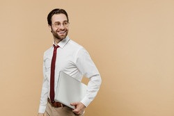 Young happy successful employee business man corporate lawyer 20s in white shirt red tie glasses work in office hold use laptop pc computer look aside on workspace isolated on plain beige background
