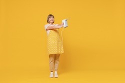 Full body elderly happy cheerful satisfied housekeeper housewife woman 50s in orange apron holding mixer cooking isolated plain on yellow background studio portrait. People household lifestyle concept