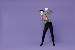 Full size body length pampering humorous young mime man with white face mask wear striped shirt beret look from behind invisible wall isolated on plain pastel light violet background studio portrait