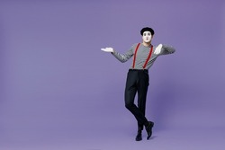 Full size body length charismatic bright young mime man with white face mask wears striped shirt beret lean on something invisible isolated on plain pastel light violet background studio portrait