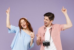 Two happy traveler tourist woman man couple in summer clothes do winner gesture point finger up isolated on purple background Passenger travel abroad on weekends getaway Air flight journey concept.