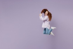 Full size body length side view dizzy crazy amusing young redhead curly green-eyed woman 20s wears white T-shirt violet jacket jumping isolated on pastel purple color wall background studio portrait