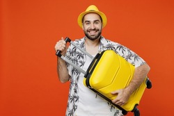 Traveler cheerful tourist man wear summer casual clothes hat hold suitcase bag isolated on plain orange color background studio. Passenger travel abroad on weekends getaway. Air flight journey concept