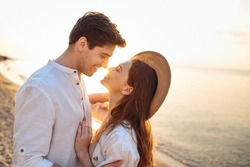 Close up profile young happy couple two friends family man woman in white clothes hug touch noses going to kiss together at sunrise over sea beach ocean outdoor seaside in summer day sunset evening.