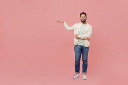 Full body young smiling happy man 20s wear trendy jacket shirt point hands show measurement scale for measuring height isolated on plain pastel light pink background studio. People lifestyle concept