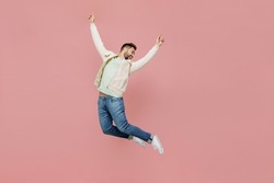 Full size young overjoyed exultant jubilant happy fun man 20s in trendy jacket shirt jump high with outstretched hands isolated on plain pastel light pink background studio. People lifestyle concept