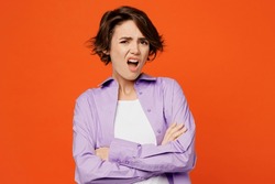 Young irritated indignant annoyed sad caucasian woman she wearing purple shirt white t-shirt casual clothes hold hands crossed isolated on plain orange background studio portrait. Lifestyle concept
