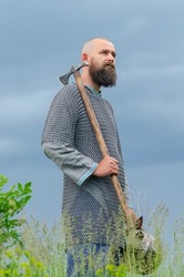 Ax in the hands of  medieval Viking warrior. Metal chain mail. Side view.  Filming  historical film.