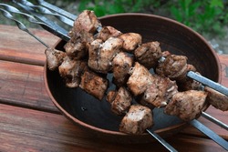 Pork meat is cooked on the grill. Close-up of pork shish kebab on skewers. Cooking in nature