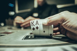 defocused blured view on the player opens the ace king combination at the poker table