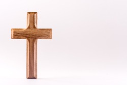 Small wooden Christian cross on a white background