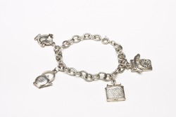 Small silver charm bracelet with 4 charms isolated against white background.