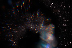 Easy to add lens flare effects for overlay designs or screen blending mode to make high-quality images. Abstract sun burst, digital flare, iridescent glare over black background. Defocused bokeh.