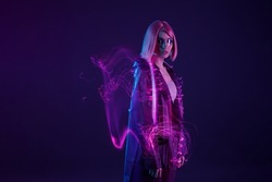Woman in futuristic costume. Female in modern VR glasses interacting with network while having virtual reality experience. Augmented reality game, future technology, AI concept. VR. Neon purple light.