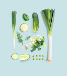 Creative layout made of green peas, dill, garlic, basil, zucchini, cucumber and green onion on the green background. Flat lay. Food concept. Macro  concept.