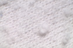 Macro of white wool textile cloth texture with lint. Selected focus. 