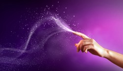 magical hand conceptual image with sparkles on colour background
