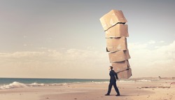 Businessman carrying big stack of carton boxes