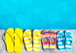 Flip flops on stone background on poolside. Summer family vacation concept