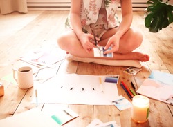 Young woman creating her Feng Shui wish map using scissors. Dreams and wishes