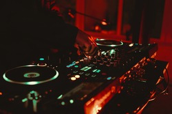 Dj playing music on concert. Club disc jockey mixing musical tracks with modern controller