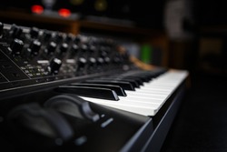 Buy synthesizer piano in music store. Professional analog synth device with classic pianist keyboard and regulators. Sound recording studio equipment for sale 