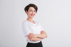 Happy Ukrainian adult woman smiling with white teeth. Beautiful female model in 40s posing in studio wearing casual white t-shirt, classic bob haircut, makeup and red lipstick