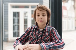Cute white boys collection of stock images. Elementary age boy sitting in a cafe. Portrait of pretty 11 year old white kid posing in diner 