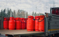 Truck deliver hazard goods, carrying red cylinders with compressed gas to customers. Delivering gas cylinders.Truck carrying gas cylinders.