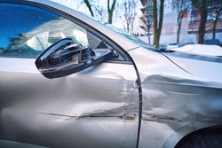 Car body side damage, traffic accident. Car door damage, broken and damaged side mirror on car door. 