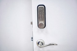 Digital door lock with metal handle. Door safety system, code keypad closeup. Open door with control system using digital locking and password to acces