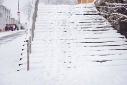 Stair steps covered with snow and ice, slippery steps hazard of injury to pedestrians. Snowy steps in winter. Slippery steps in cold season. Unclean stairs in winter. Staircase covered with deep snow
