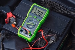 Measurement of car battery voltage. Good car battery, almost fully charged voltage - 12.5V.  Battery capacity tester voltmeter. Check voltage with multimeter. Test battery health
