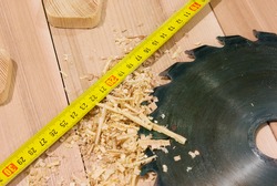 circular saw lying on the desktop, including sawdust and tape-measure