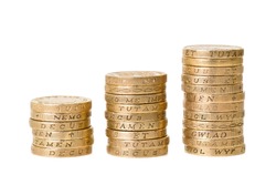 Three stacks of British one pound coins on white