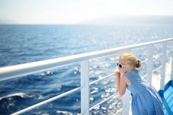 Adorable young girl enjoying ferry ride staring at the deep blue sea. Child having fun on summer family vacation in Greece. Kid sailing on a boat.