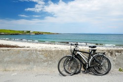 Two bikes near sandy beach on Inishmore, the largest of the Aran Islands in Galway Bay, Ireland. Famous for its strong Irish culture, loyalty to the Irish language, and a wealth of ancient sites.