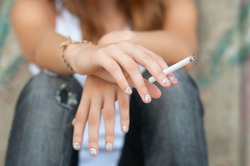 Teenage hands holding cigarette.
